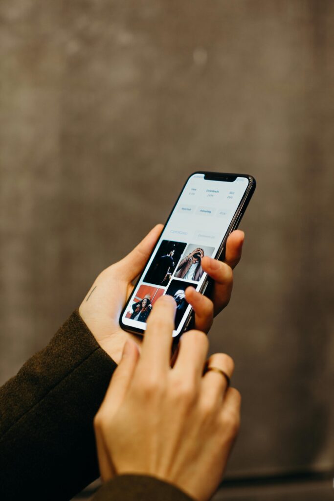 pexels-photo-3585088-3585088 Close-up of hands using a smartphone to browse a photo gallery app, showcasing modern technology.
